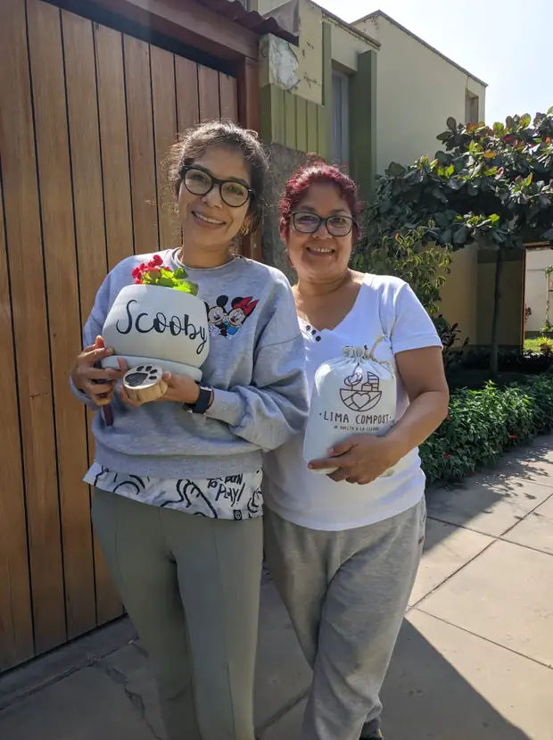 Dos mujeres con la maceta de Scooby y su bolsa de compost