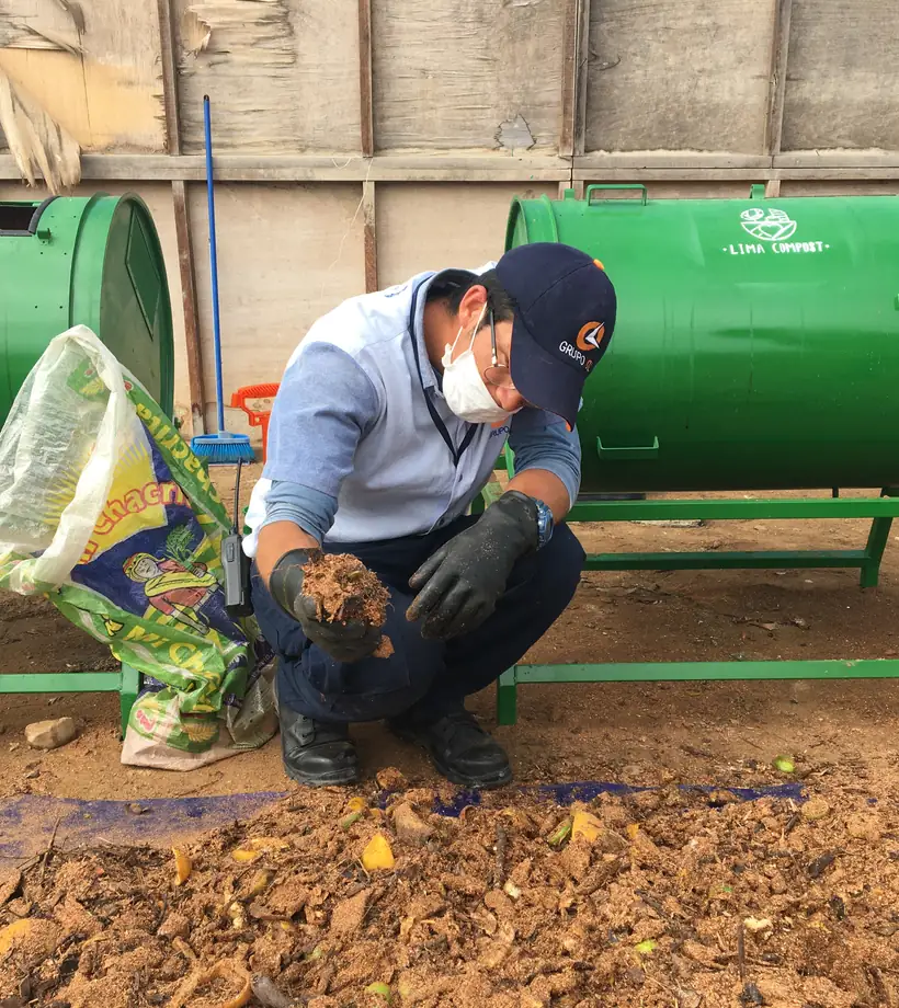 Operario de Lima Compost cargando residuos orgánicos en la compostera de cilindro