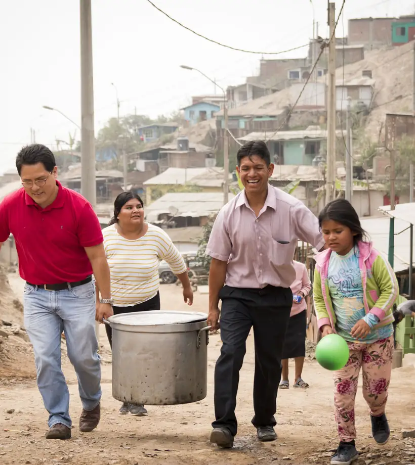 Familia caminando con sus baldes de residuos orgánicos camino al punto de acopio