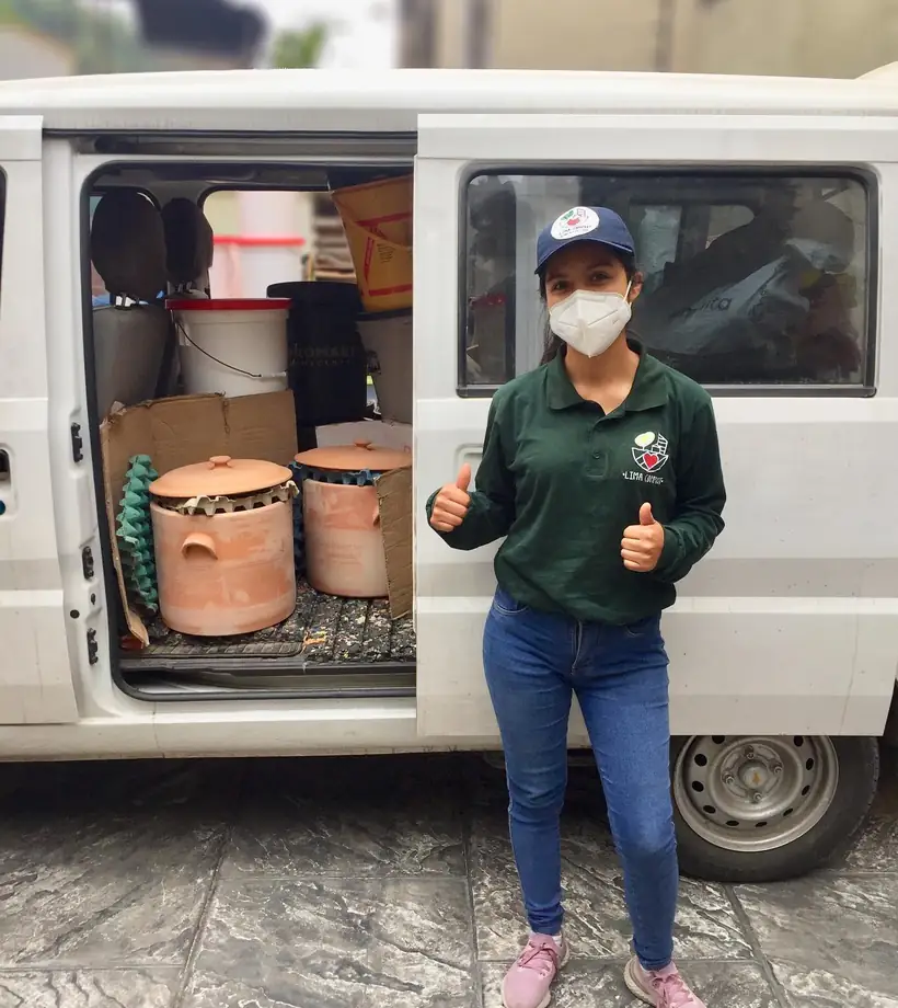 Integrante del equipo de Lima Compost junto a la movilidad cargada con los equipos, lista para montar un punto de acopio